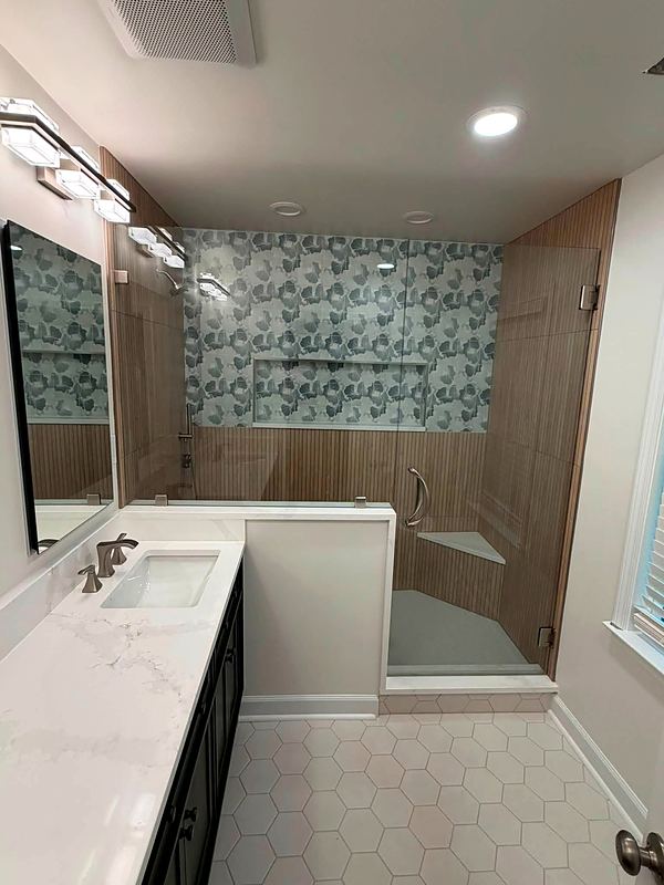 After: glass shower with a patterned tile wall, new vanity and hexagon floor tile