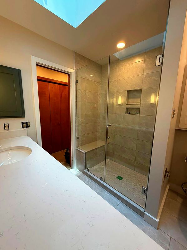 After: glass shower with large-format wall tile, bench and two niches