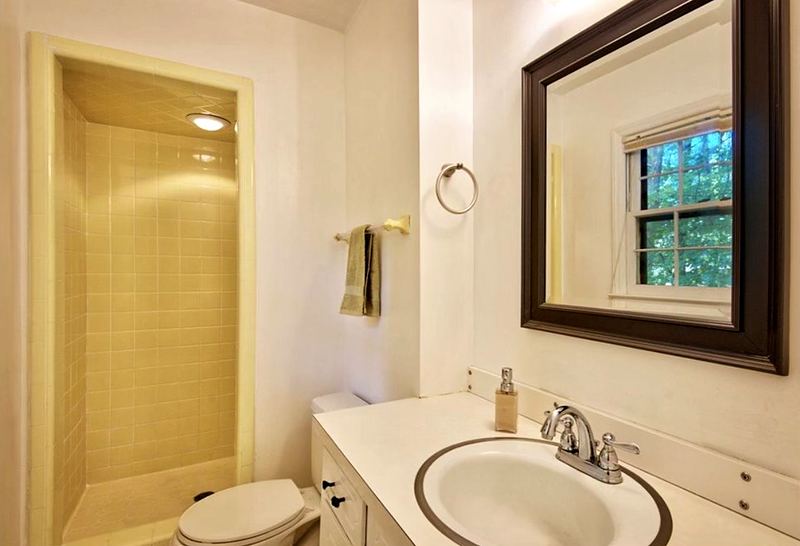 Before: small bathroom with an enclosed tile shower stall